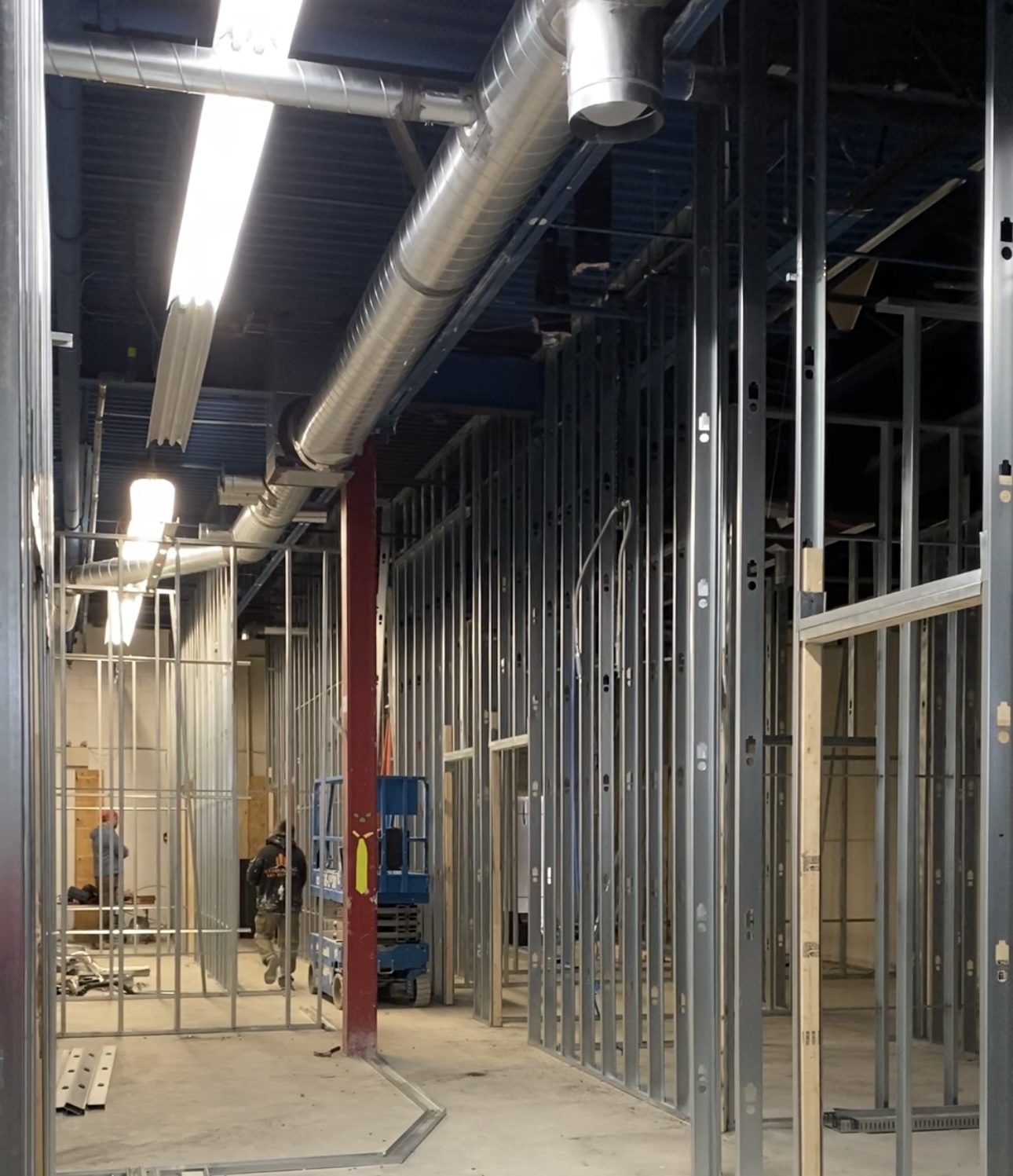Commercial renovation project with steel wall framing and ductwork installation during construction phase