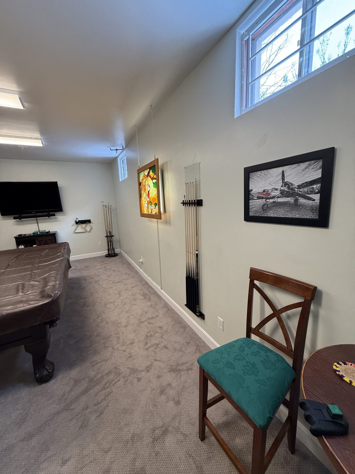 Finished basement renovation with wall-mounted pool cues, billiards table, flat-screen TV, and custom lighting completed by Loon Renovation in Newmarket, Ontario